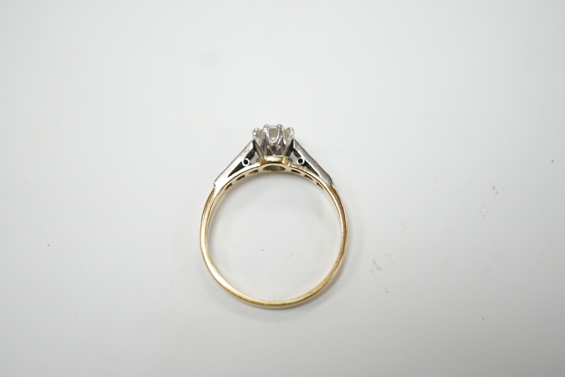 An early 20th century 18ct, plat. and single stone diamond set ring, with six stone diamond chip set shoulders, size O, gross weight 2.3 grams. Good condition.